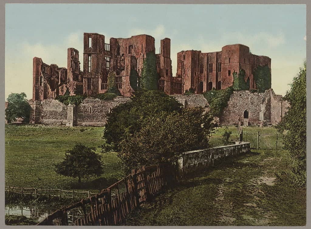 Photochrome print of the ruins of Kenilworth Castle in England. The red castle rises in the background. In the foreground are a lawn, trees, and an old fence. 

Some versions of 