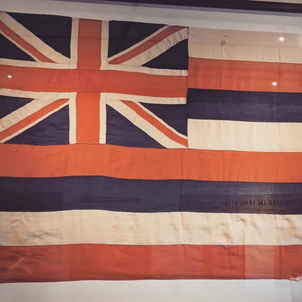 The flag of the Kingdom of Hawai'i. In the upper-left is the Union Jack, the flag of Great Britain. Eight stripes represent Hawai'i's eight major islands in red, white, and blue.